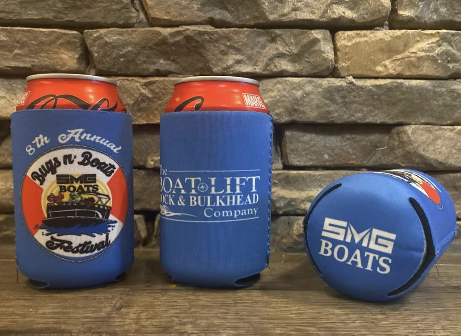 Blue can koozies and a foam football branded with SMG Boats and Boat Lift Company logos