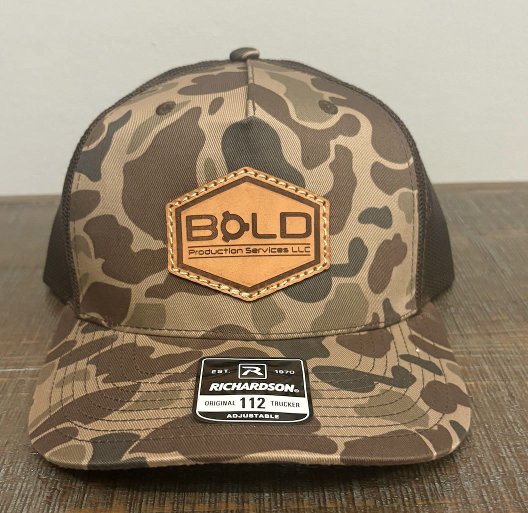 Camo Richardson 112 trucker hat with a BOLD Production Services LLC leather patch