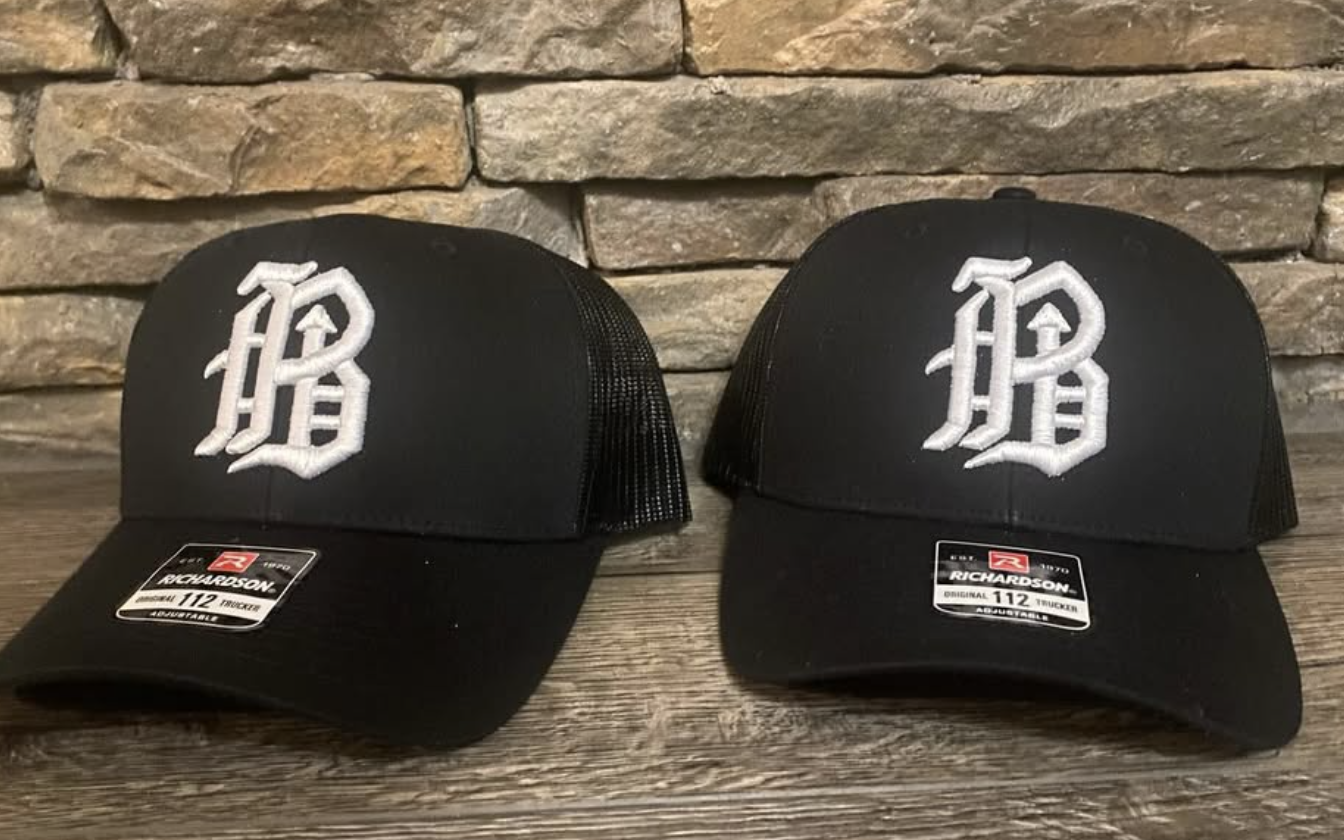 Two black trucker caps with white 3D puff embroidered monogram