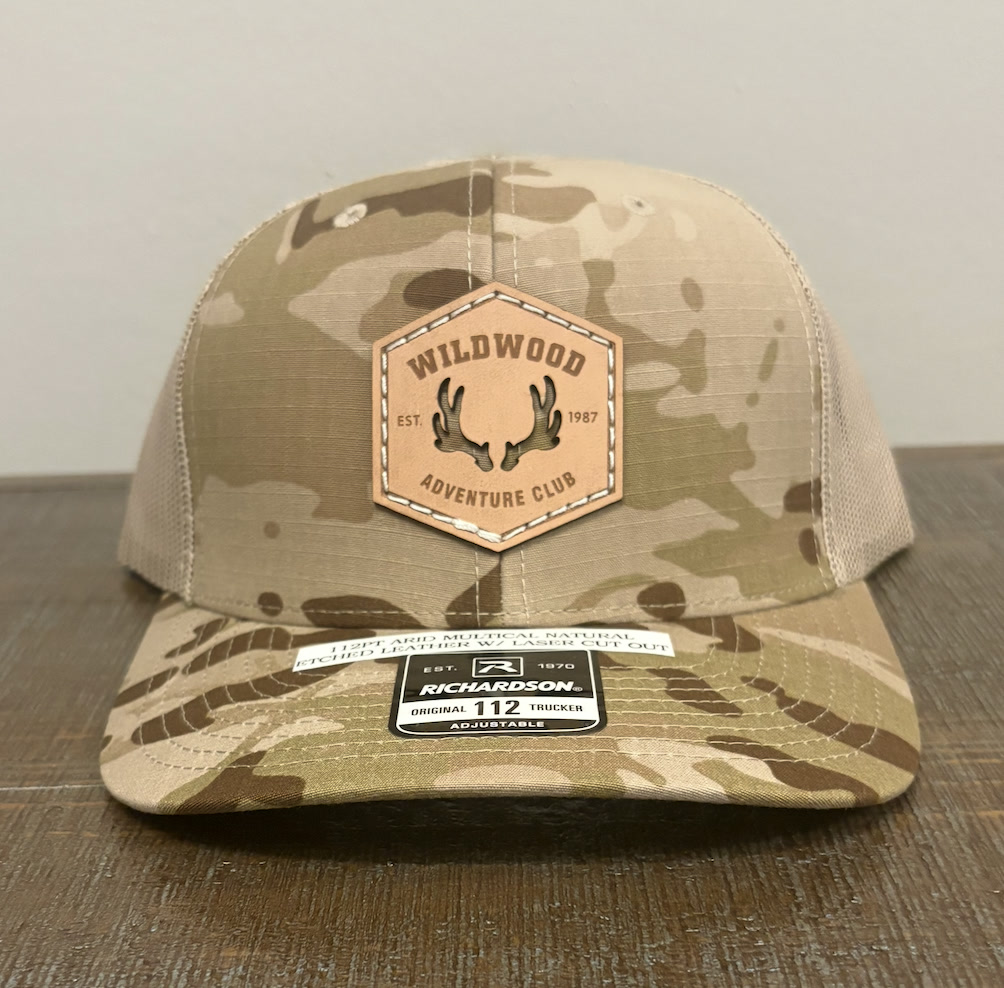 Camo Richardson 112 trucker hat with a Wildwood Adventure Club leather patch