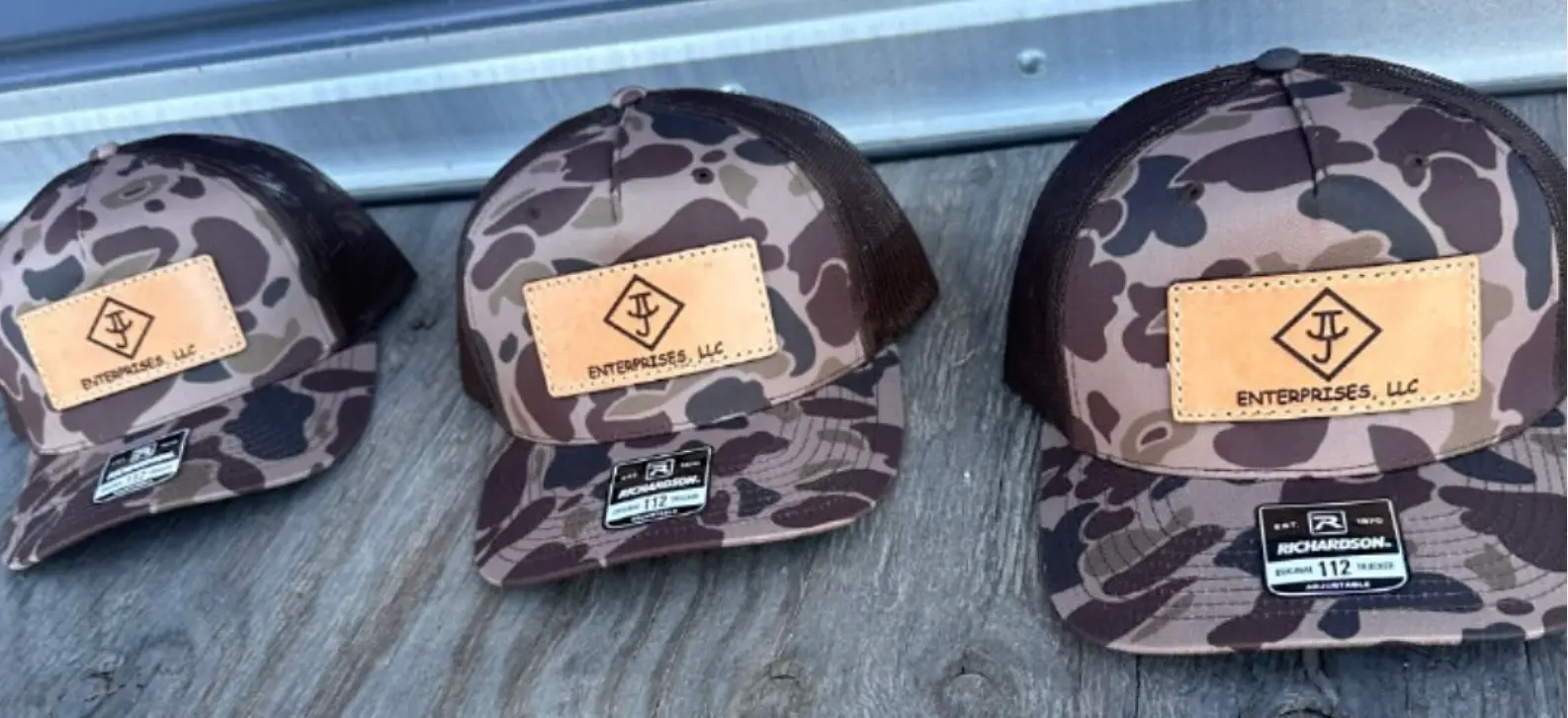 Three camo Richardson trucker caps with leather J Enterprises patches