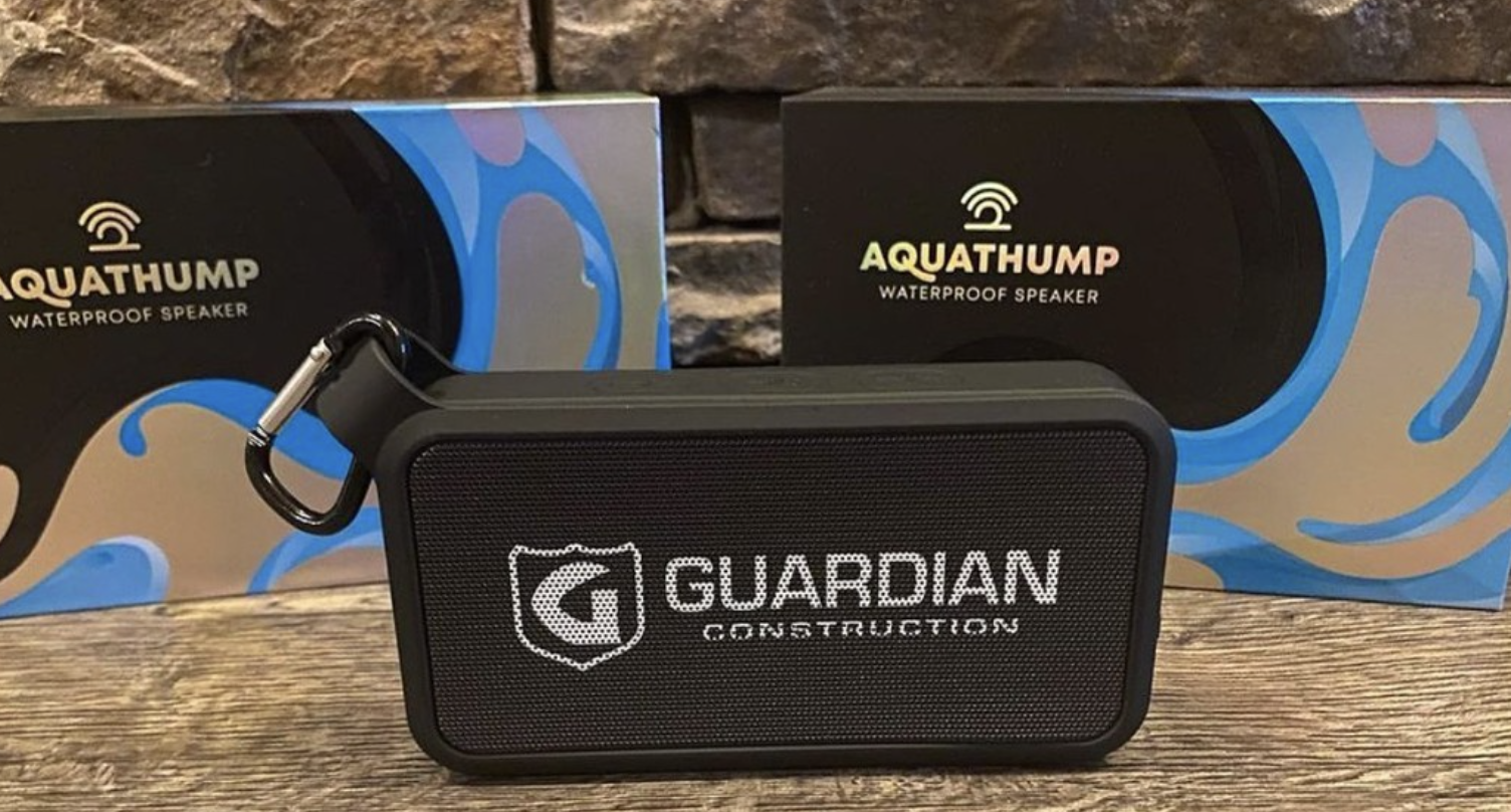 Black Aquathump waterproof speaker branded with Guardian Construction logo